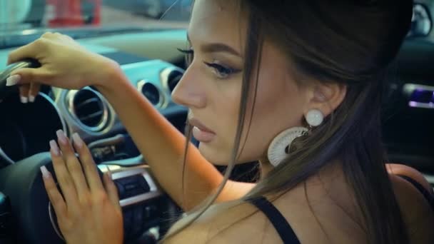 Wanita cantik muda memilih mobil baru di dealer. Dia senang, tersenyum dan bersukacita dalam membeli transportasi baru — Stok Video