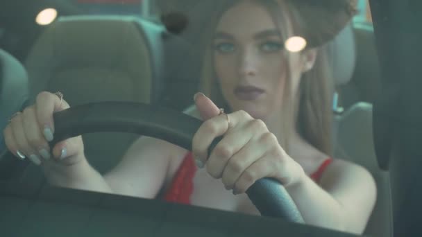 รูปภาพของหญิงสาวที่สวยงามนั่งในรถภายในด้วยมือบนพวงมาลัยในงานแสดงรถยนต์ — วีดีโอสต็อก