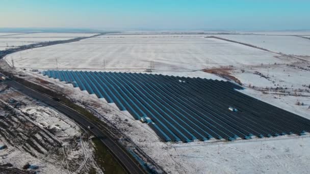 Vista aérea da moderna central solar com neve perto da estrada com carros e caminhões no inverno — Vídeo de Stock