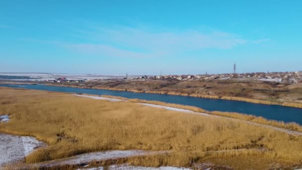 Παγωμένος ποταμός χειμώνα κοντά στην εθνική οδό με την κίνηση βαρέων φορτηγών κάτω από μπλε ουρανό — Αρχείο Βίντεο