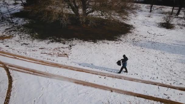 Uomo in giacca blu e grigia con zaino escursionismo all'aperto nel bosco innevato in inverno — Video Stock