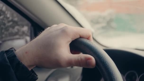Closeup of person hand on steering wheel when man driving car in winter — Stock Video