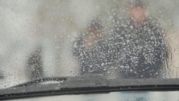 Silhuetas de paisagem urbana de pessoas que caminham do pára-brisa do carro com limpadores no inverno — Vídeo de Stock