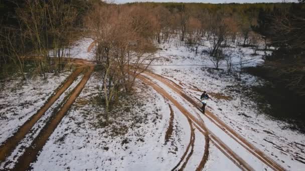 Människan turist promenader genom snötäckt mark i skogen på solig vinterdag. Vandrare med ryggsäck och papperskarta över området — Stockvideo