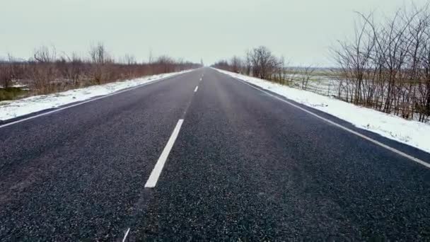 Camino del automóvil en invierno paisaje entre campos agrícolas en nevadas — Vídeo de stock