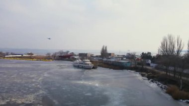 Yolcu helikopteri, donmuş limanda ya da limanda eriyen buzla birlikte zevk gemisinin üzerinden uçar.
