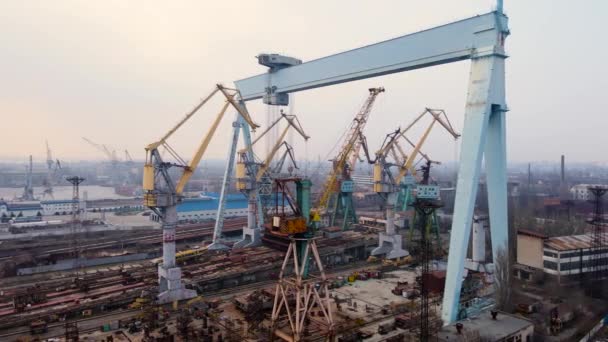 Panorama aéreo sobre grúa de carga enorme en astillero con graneros metálicos en puerto internacional con terminal comercial y muelles — Vídeos de Stock