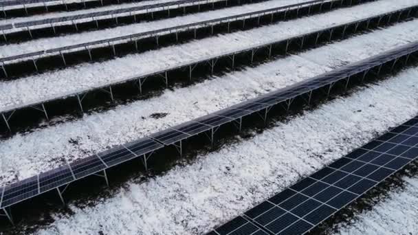 Güneşli hücreleri olan karlı topraklardaki yeni güneş çiftliğini kapatın. Modern paneller temiz elektrik üretir — Stok video