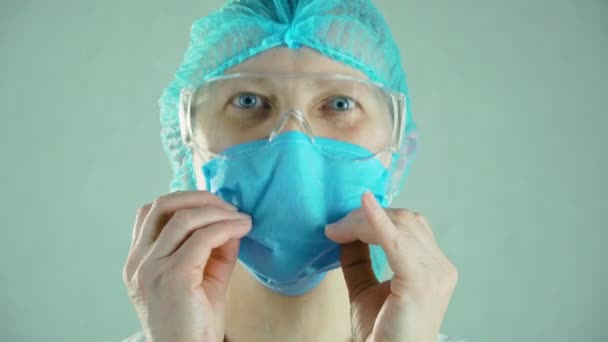 Retrato de enfermeira médica feliz em óculos de proteção tirar máscara facial e sorrir durante a pandemia de coronavírus — Vídeo de Stock