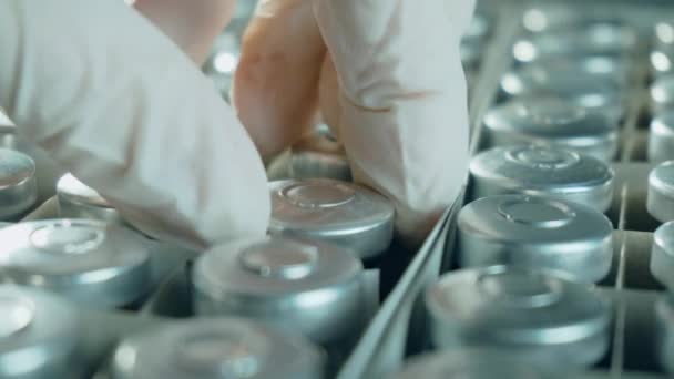 Hand of scientist doctor in protective gloves taking vial or ampoule with coronavirus vaccine from box before injection — Stock Video