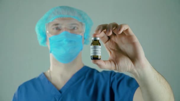 Científico masculino con ampolla en la mano, desarrollo de nuevos medicamentos, vacunación — Vídeo de stock