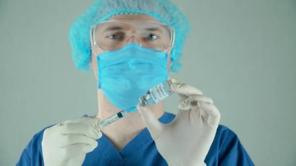 Lékař mikrobiolog virolog vědec v laboratoři v ochranné masce a rukavicích s ampulí s vakcinační injekcí a injekční stříkačkou — Stock video