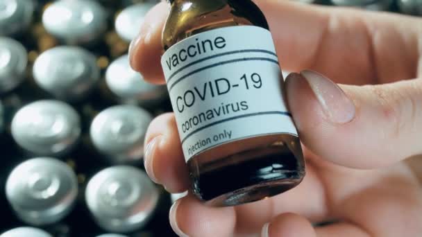 Крупним планом пляшки з коронавірусною вакциною або флакони в руці, що показують фармацевтичну промисловість — стокове відео