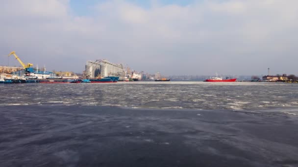 Imagens de drones aéreos de terminais de carga em água gelada com navios e guindastes portuários em tanques de armazenamento de cais e grãos — Vídeo de Stock