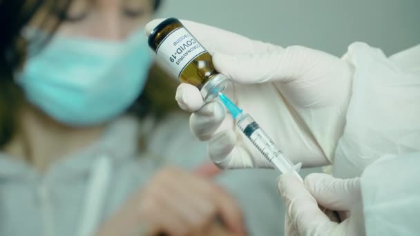 Медицинское вакцинационное оборудование с иглой и ампулой в руке врача или медсестры на фоне пациента — стоковое видео
