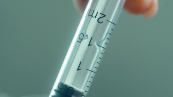 Заполнение медицинского шприца иглой коронавирусной вакциной для инъекций в клинике, экстремальный макрос — стоковое видео