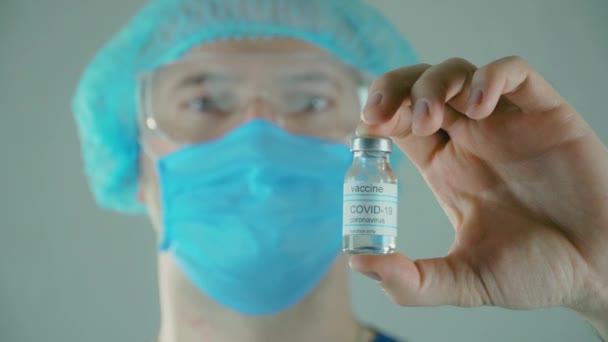 Médico virólogo masculino sosteniendo frasco de medicamentos farmacológicos contra la vacuna contra el coronavirus después de la fabricación — Vídeo de stock
