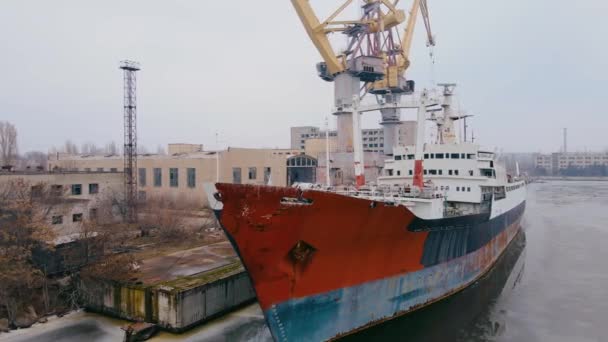 Abandoned sunken rusty ship for many years moored in harbor with cargo multi tonnage cranes and commercial buildings — Vídeo de Stock