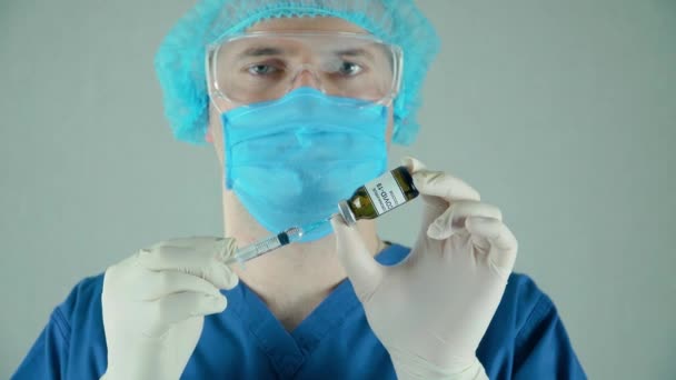 Medische laboratoriummedewerker in beschermende handschoenen masker klaar om ampul of fles in te voeren met anti coronavirus moderna vaccin in bacteriologisch laboratorium — Stockvideo