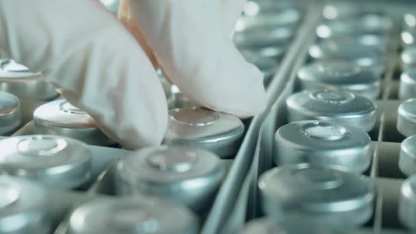 Koruyucu eldivenli bir sağlık çalışanı kutudan koronavirüs aşısı şişesi ya da şişe alır. Yeni ilaçlar geliştirir. — Stok video