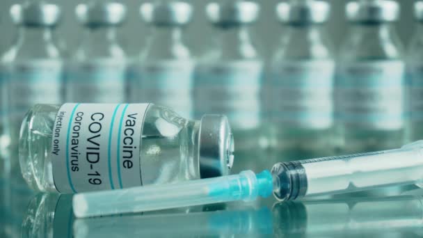 코로나 바이러스 예방 백신이 들어 있는 병이나 병 그리고 의료 센터에 있는 거울 탁자 위에 주사를 놓기 위한 주사기는 열 처리 증기를 받는다 — 비디오