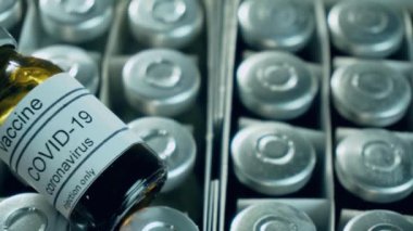 Tıbbi hizmetler merkezinde enjeksiyon için kutu içinde koronavirüs aşısı olan ampulleri kapatın.