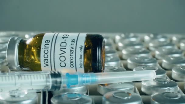 Fiolki lub butelki ze szczepionką przeciw koronawirusowi i strzykawką w pudełku do wstrzykiwań w centrum usług medycznych — Wideo stockowe