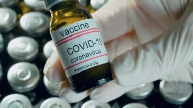 Laboratuvar araştırmacısı elinde aşı şişesi tutuyordu. Küresel aşılama için eczane şişeleriyle birlikte ilaç kullanıyordu.