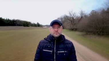 Koronavirüs hastalığının zamanlaması kendini izole etme ve karantinaya alma süresince ormanın yakınındaki kumlu kır yolunda yürüyor.