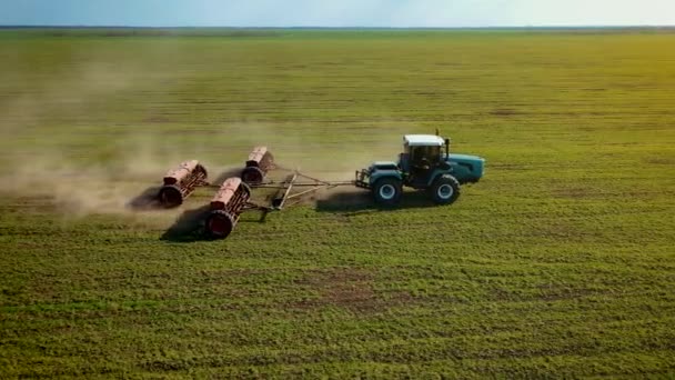 Fechar trator poderoso moderno espalhando fertilizantes artificiais no campo com culturas crescentes de cevada ou trigo para aumentar a produtividade — Vídeo de Stock