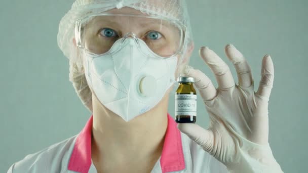 Vrouwelijke onderzoeker in beschermende steriele kleding met medische buis en vaccinmonsters in het laboratorium — Stockvideo