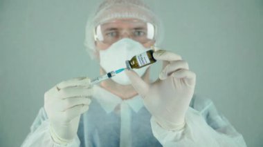 Doktor ya da biyolog şırıngayı iğneyle dolduruyor. Aşıyı laboratuvarda sıvı ilaçla tutuyor.
