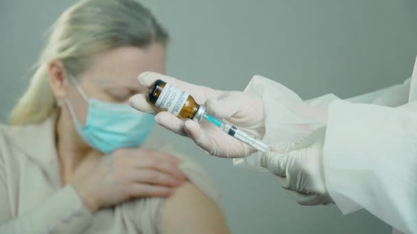 Matériel médical de vaccination avec aiguille et ampoule dans la main du médecin ou de l'infirmière sur fond de patiente hospitalisée — Video