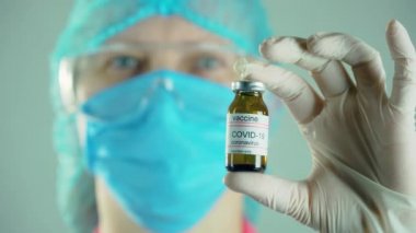 Tıbbi virolog, ilaç ürettikten sonra bir şişe koronavirüs aşısı ilaç tutuyor.