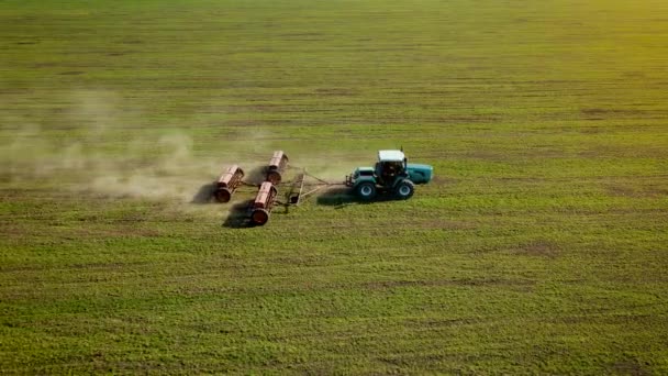 Krachtige trekker die kunstmest verspreidt in het veld met teelten van gerst of tarwe om de productiviteitsverhoging kolom van stof te verhogen — Stockvideo