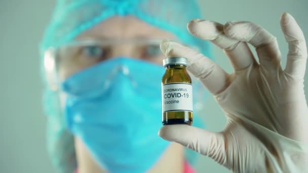 Закрыть коронавирусную вакцину выявить в медицинской лаборатории. Ампула или бутылка с аптечными препаратами — стоковое видео