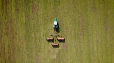 Agronomik güçlü traktör bahar tarlasına gübre yayıyor. Arpa tarlasının büyüyen havadan bakımıyla birlikte.