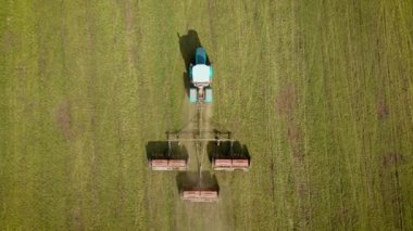 Çağdaş tarımsal birime sahip güçlü tekerlekli traktör kullanılarak tahıl arpası ve buğday ekinlerine katı gübre uygulanması üzerine tepeden aşağı bakış