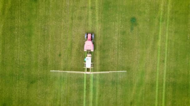 Trator agrícola pulverização no campo de trigo verde com pesticidas pulverizador, vista drone superior — Vídeo de Stock