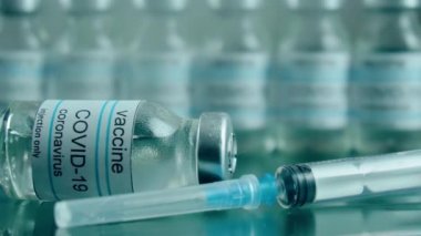 Coronavirus 'tan korunmak için şırıngayla eczane şişelerinde aşı, tıp araştırma laboratuvarında ısı tedavisi görmektedir.