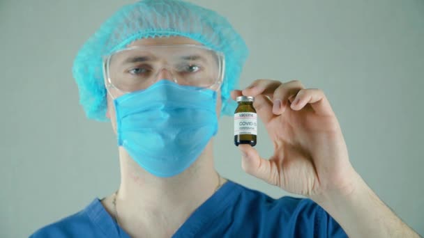 Arts voert onderzoek, hand holding flacon of fles met anti-coronavirus vaccin — Stockvideo