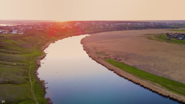Piękny zachód słońca na błękitnej europejskiej rzece pod malowniczą wioską na wzgórzach - nagranie drona — Wideo stockowe