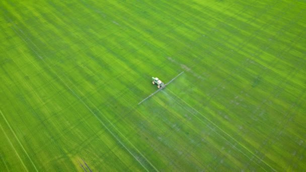 Vista aérea da agricultura trator pulverização no campo de trigo com herbicidas e pesticidas ao pôr do sol. Actividade agrícola natural sazonal da Primavera — Vídeo de Stock