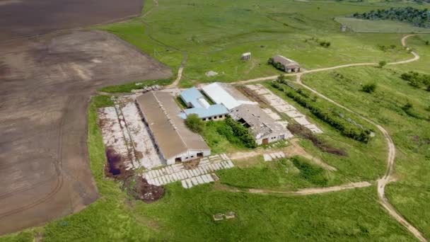 Ruínas da antiga fazenda abandonada para manter vacas e porcos com buracos de concha no telhado e paredes quebradas — Vídeo de Stock