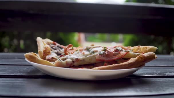 Pizza quente picada com cogumelos de carne de queijo e tomates na placa na mesa de madeira logo após a entrega — Vídeo de Stock