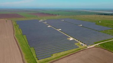 Yenilenebilir elektrik ve enerji hattı üretmek için güneş enerjisi hücreleri sıra sıra güneş enerjisi üreten güneş çiftliğinin havadan görünüşü