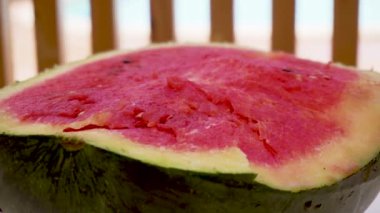 Lezzetli, tatlı, lezzetli karpuz siyah tohumlar ve kokulu posayla ikiye bölünmüş.