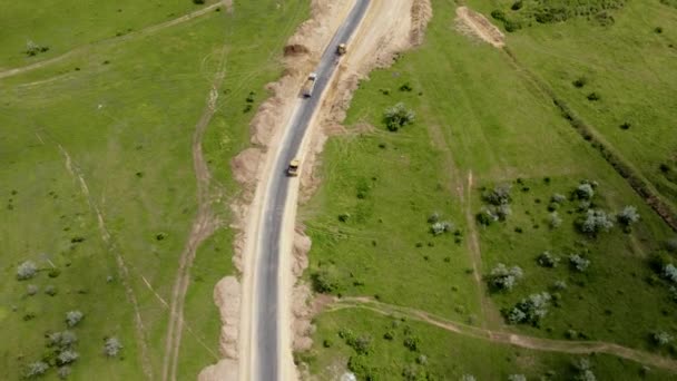 Grande caminhão de descarga de carga poderosa com corpo inteiro de areia está dirigindo a construção de passadeiras de máquinas pesadas e aves voando sob ele — Vídeo de Stock