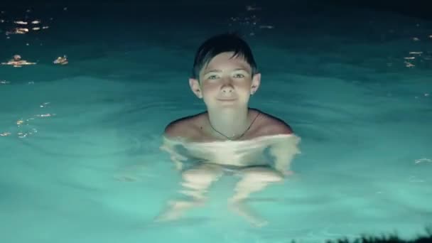 笑顔ティーン男の子でプールで夜 — ストック動画