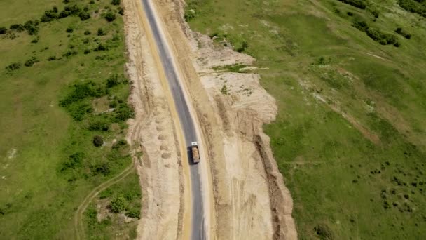 採石場から道路の建物に砂を輸送する鉱山トラック。鉱山機械の作業の空中ビューと私から粘土を移動 — ストック動画